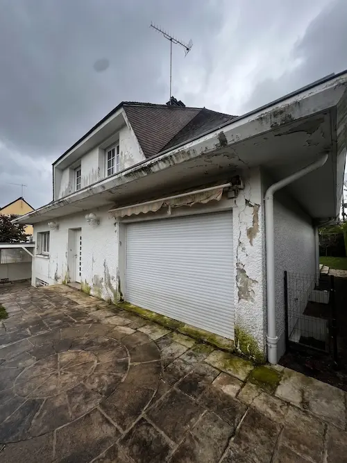 La même façade avant travaux — enduit fissuré, traces de mousse et de pollution